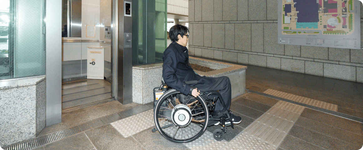 地下通路のエレベーター前に立つ様子